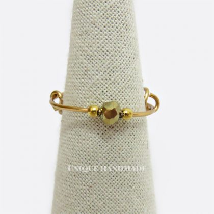 Anello regolabile realizzato a mano con mezzo cristallo dorato.