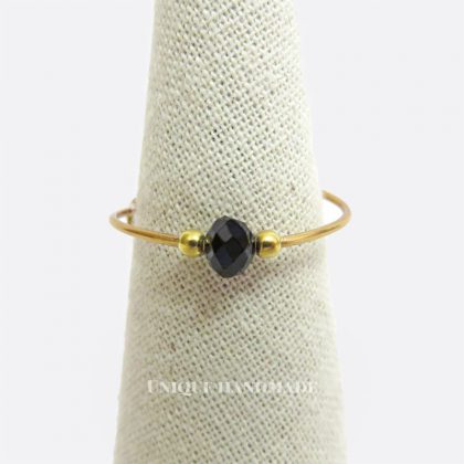 Anello regolabile realizzato a mano con mezzo cristallo nero da 4 mm tra due perline da 2 mm.