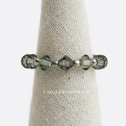 Anello elastico realizzato a mano con mezzi cristalli distanziati da perline argentate da 2 mm.