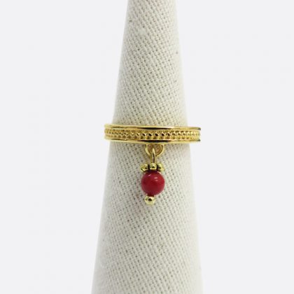Anello dorato in stile etnico con ciondolo su coccu rosso