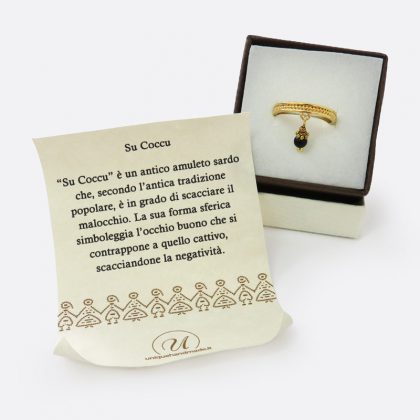Anello dorato in stile etnico con ciondolo su coccu, realizzato a mano con una perlina di onice nera.
