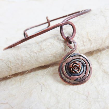 Bracciale rigido con un ciondolo avente una piccola rosa centrale, realizzato a mano con la tecnica wire.