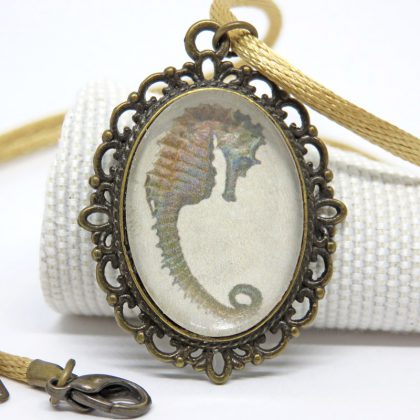 Collana in stile vintage realizzata a mano con medaglia con un cavalluccio marino. La collana di cordoncino satinato si chiude con moschettone.
