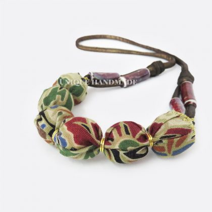 Collana tessile realizzata a mano con perle rivestite in tessuto dai motivi etnici.
