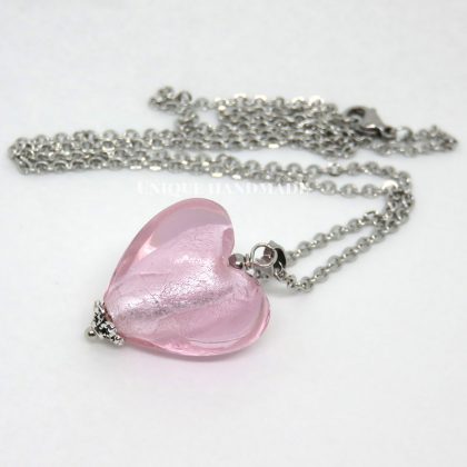 Collana realizzata a mano con ciondolo a forma di cuore in vetro rosa montato su una catenina in acciaio inox.