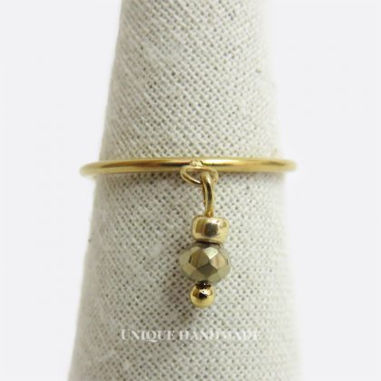 Anello in acciaio realizzato a mano con pendente dorato composto da un mezzo cristallo dorato e perlina in vetro dorata.