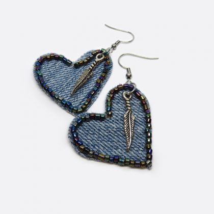 Orecchini realizzati a mano con pendente in denim a forma di cuore decorato con perline cangianti e piuma in metallo.