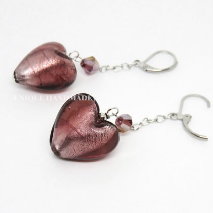 Orecchini realizzati a mano con pendente a forma di cuore in vetro magenta.