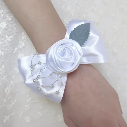 Bracciale corsage per damigelle fatto a mano con un fiocco di raso bianco e rosa centrale.