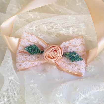 Bracciale corsage fatto a mano con un fiocco di raso color rosa pesca.