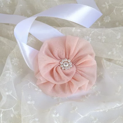 Bracciale corsage fatto a mano con un fiore in morbido tulle color rosa pesca.